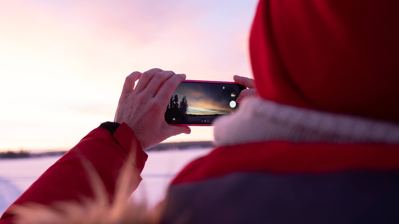 Sonnenuntergang in Lappland wird mit Smartphone fotografiert
