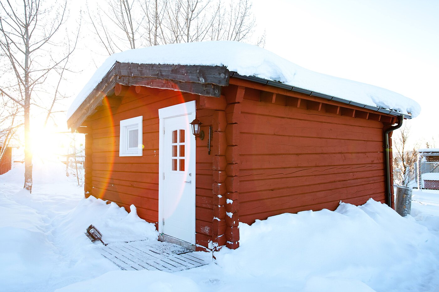 Rotes Blockhaus im Schnee in Lappland