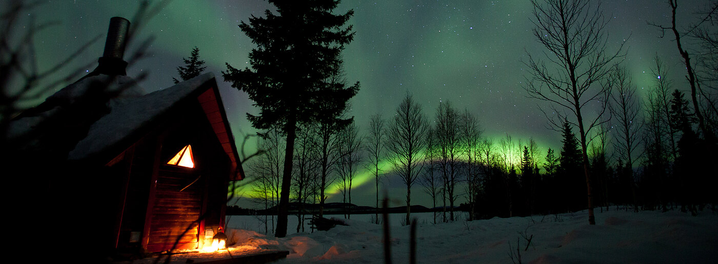 Nordlichter über Hütte in Lappland bei Nacht