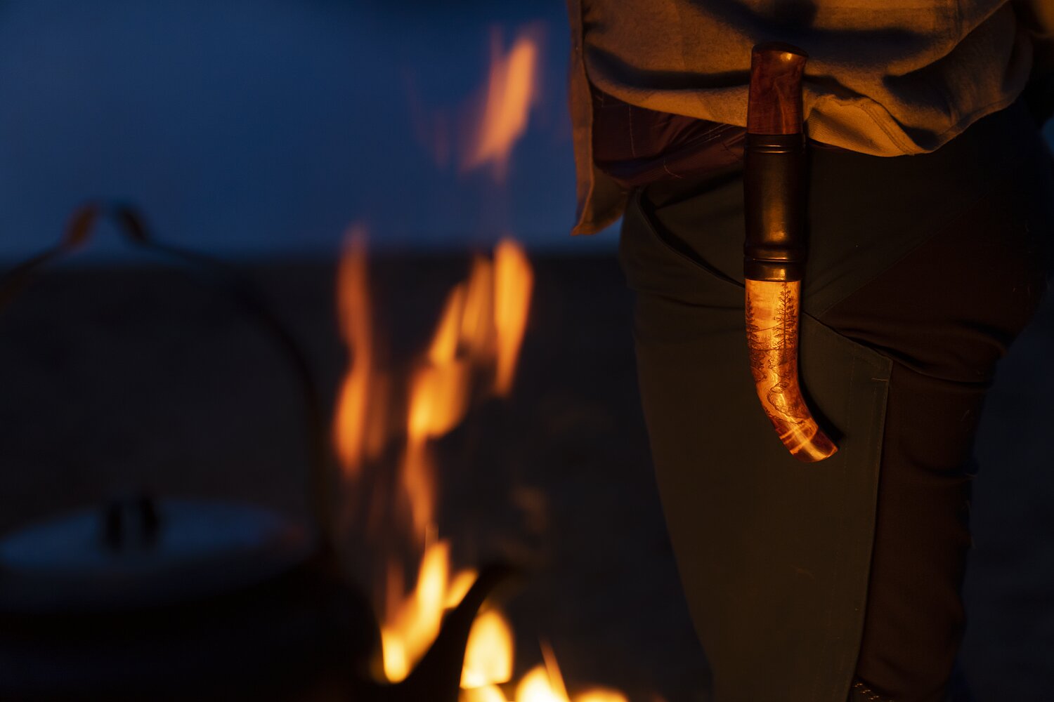 Lagerfeuer in Lappland mit Messer im warmen Licht
