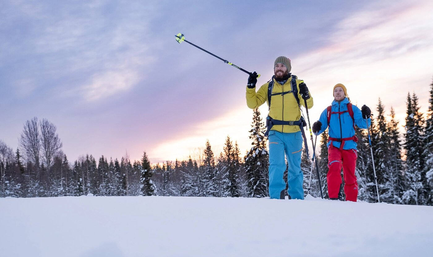Zwei Personen stehen im Schnee bei Wintertour in Lappland