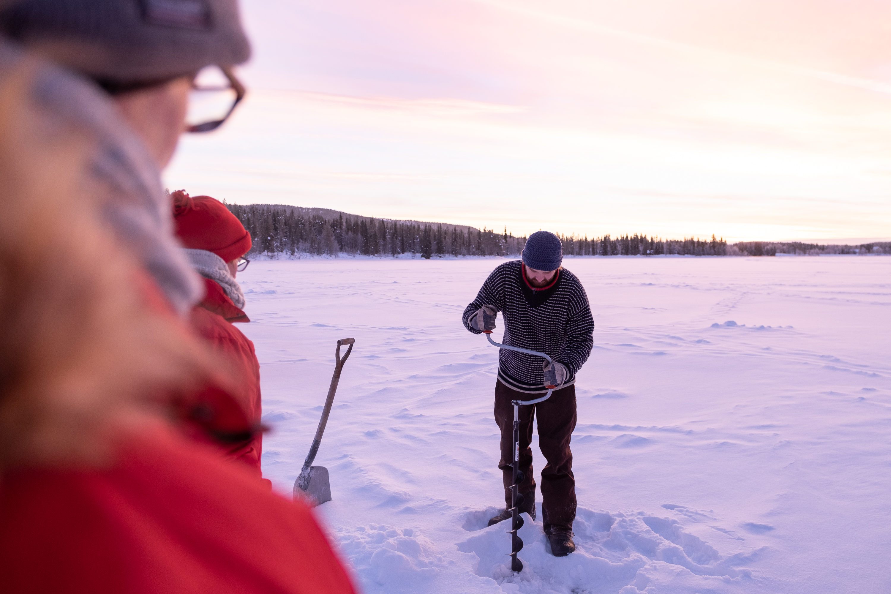 Loch bohren beim Eisangeln Lappland
