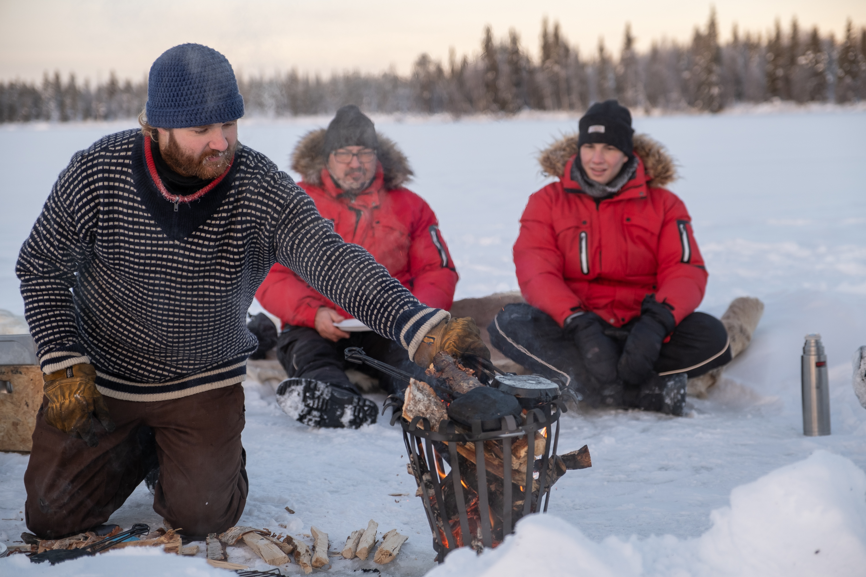 Pause am Feuer beim Eisangeln Lappland