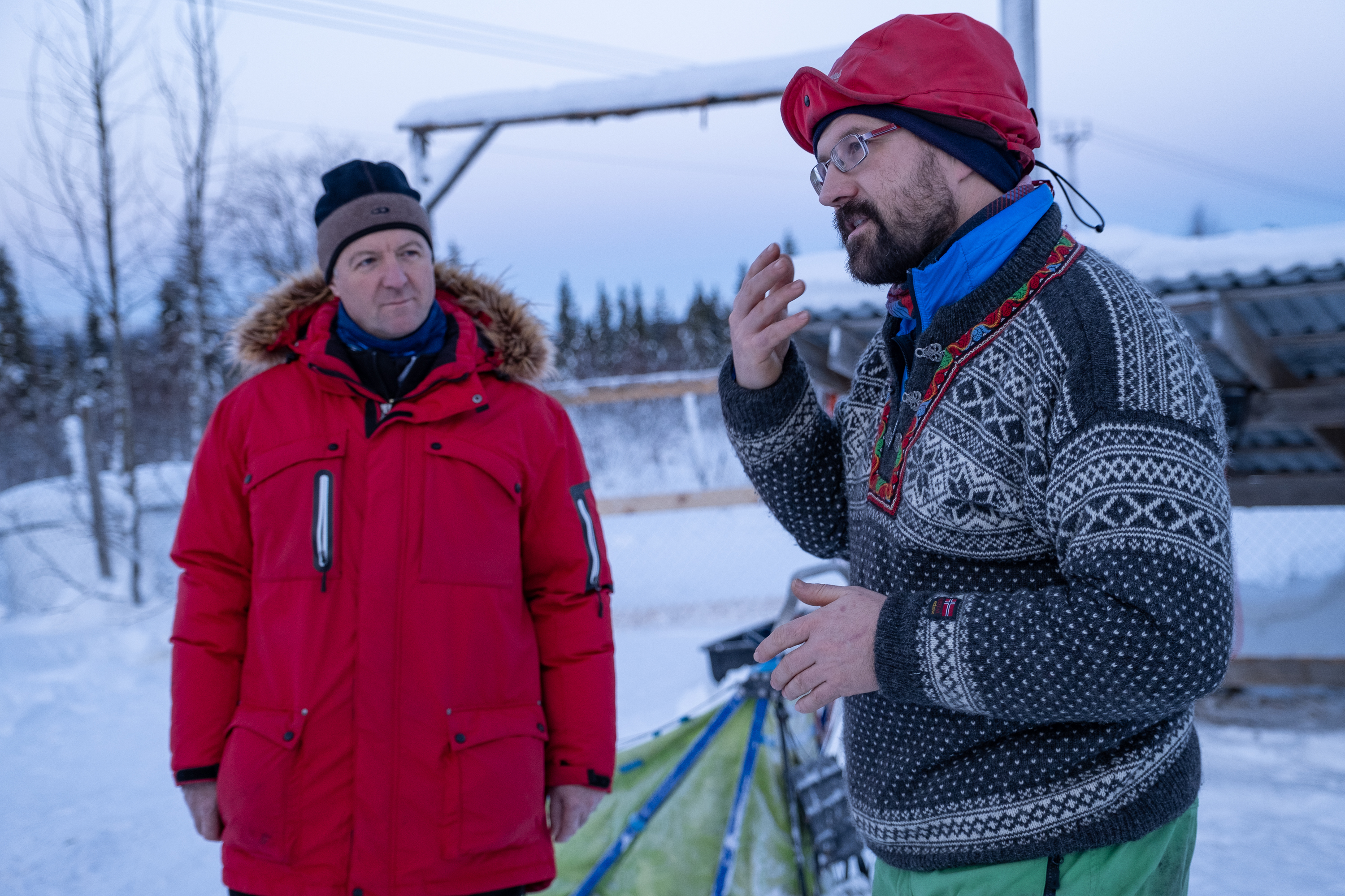 Guide erklärt Hundeschlittenfahren Gruppe in Lappland