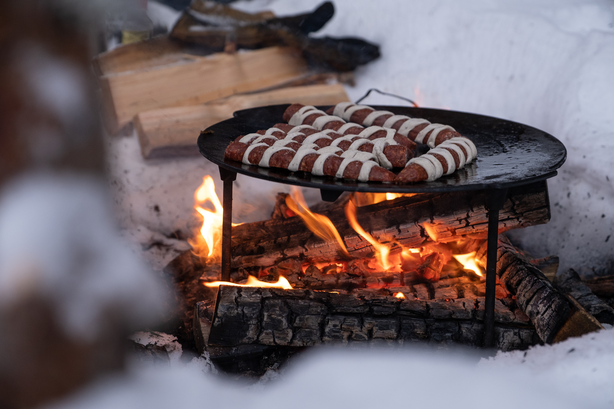 Kochen am Lagerfeuer beim Schneeschuhwandern Lappland