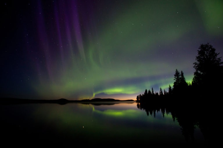Polarlicht in verschiedenen FArben spiegelt sich im See
