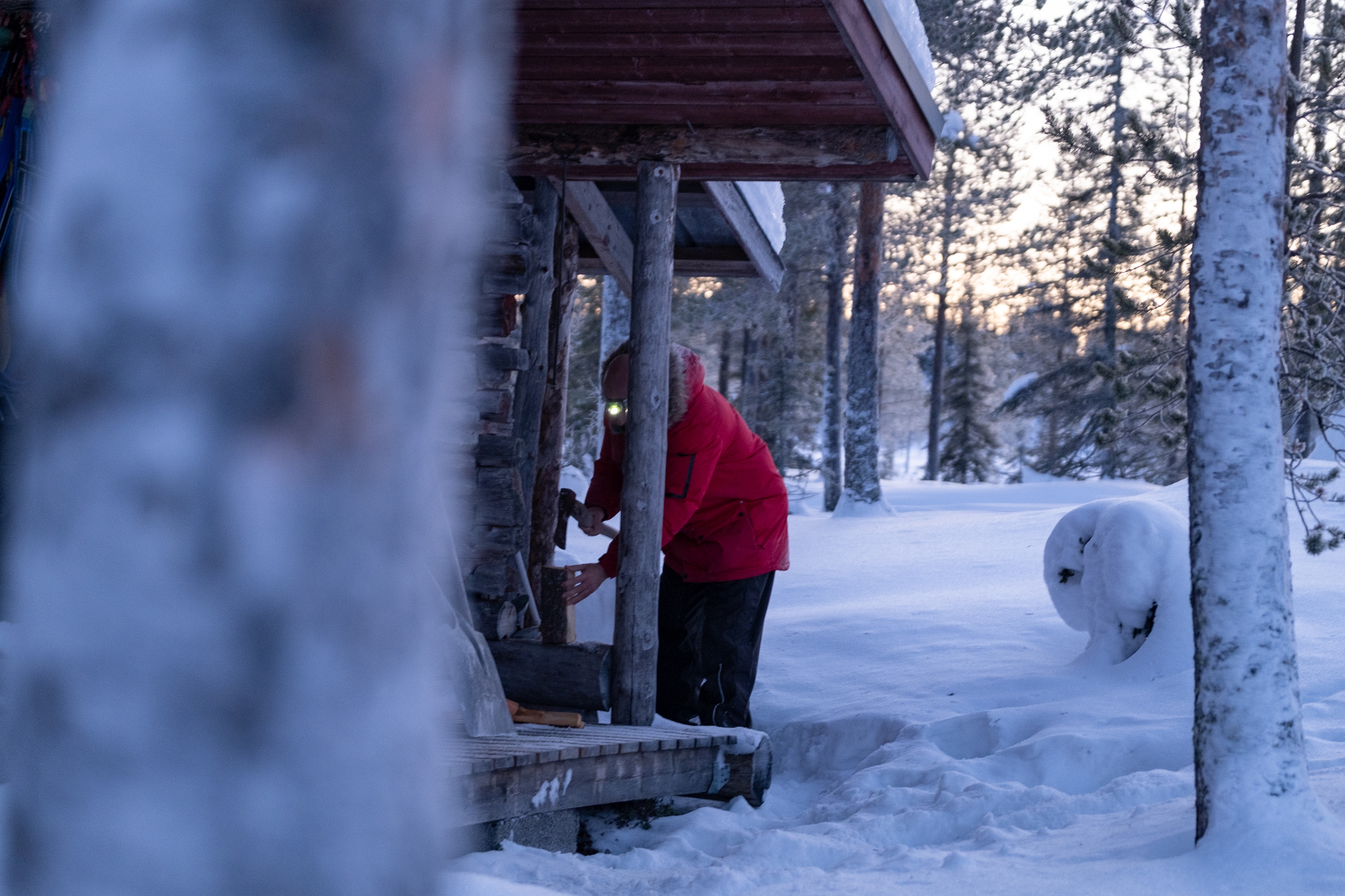 Gast betritt Hütte im Schnee bei Huskytour Silvester in Lappland